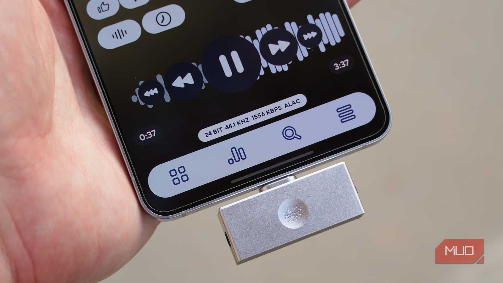 A USB-C DAC plugged into an Android phone playing ALAC music files.