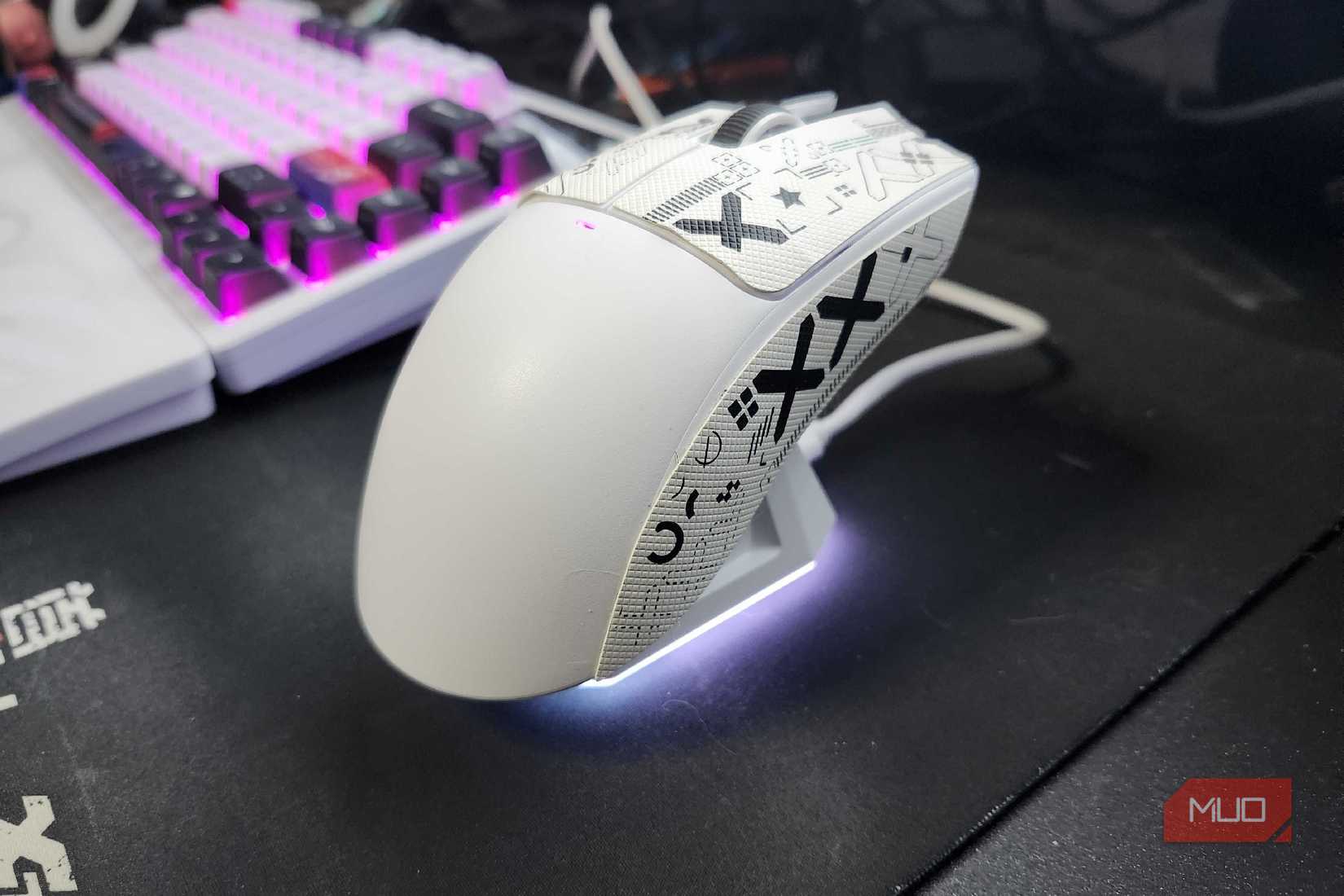 The Attack Shark X11 resting on the charging dock, with an LED light illuminating the bottom of the dock