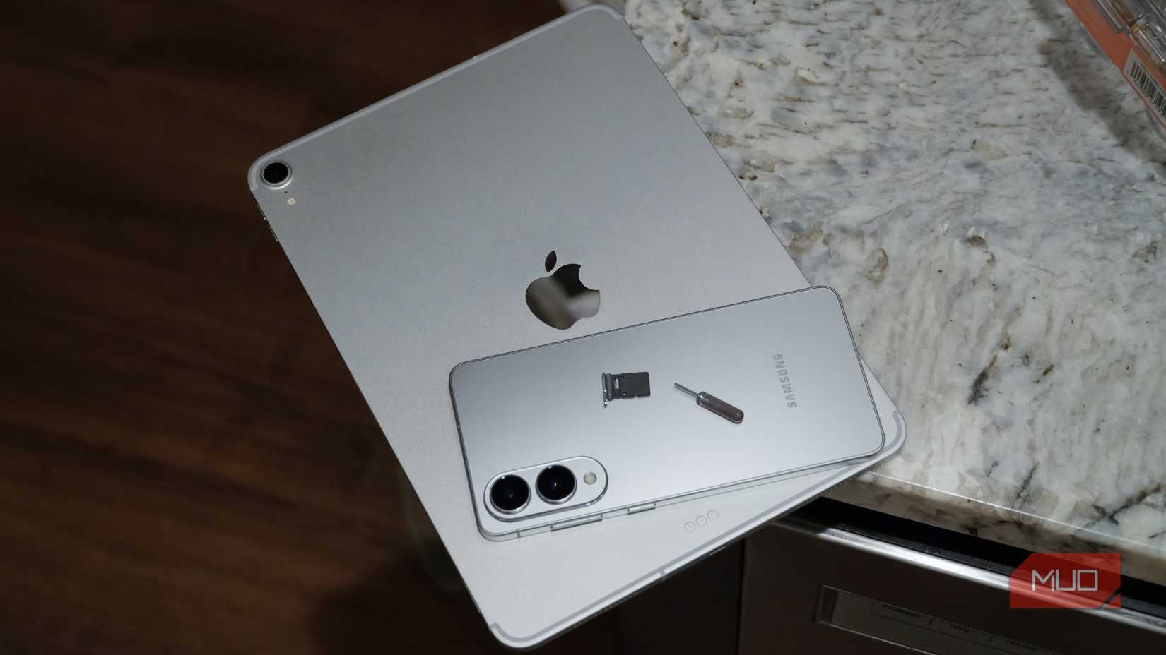 Un iPad Pro y un Galaxy S25 Edge con bandeja para tarjeta SIM.