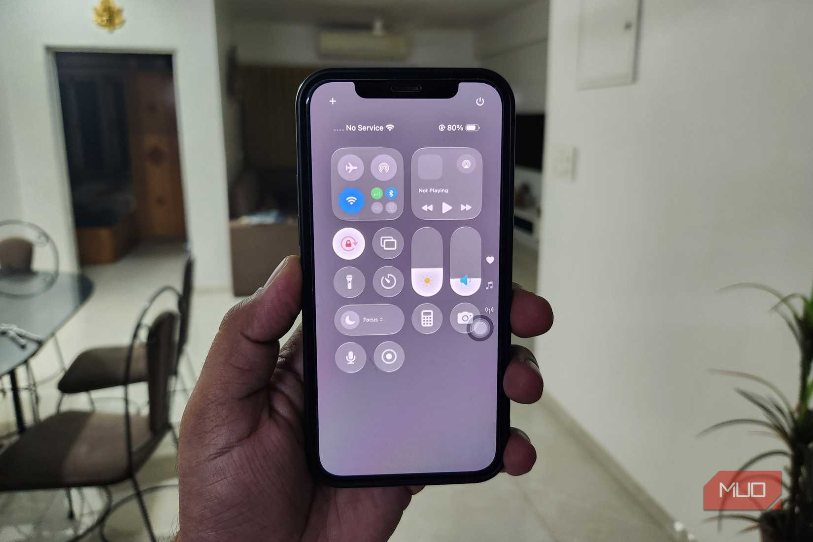 iPhone 12 in hand showing control center