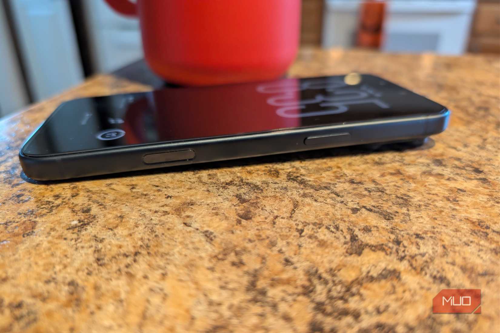 A iPhone 17 Pro Max in a kitchen with a coffee cup with a screen protector on.