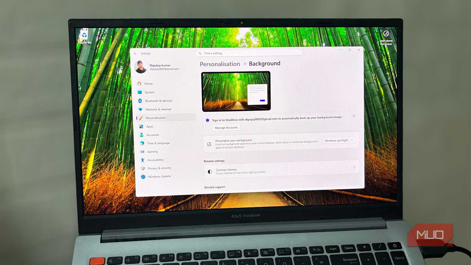 ল্যাপটপ একটি পরিষ্কার, ফোকাসড ডেস্কটপ চেহারা সহ Windows 11 ব্যাকগ্রাউন্ড সেটিংস দেখাচ্ছে। -1