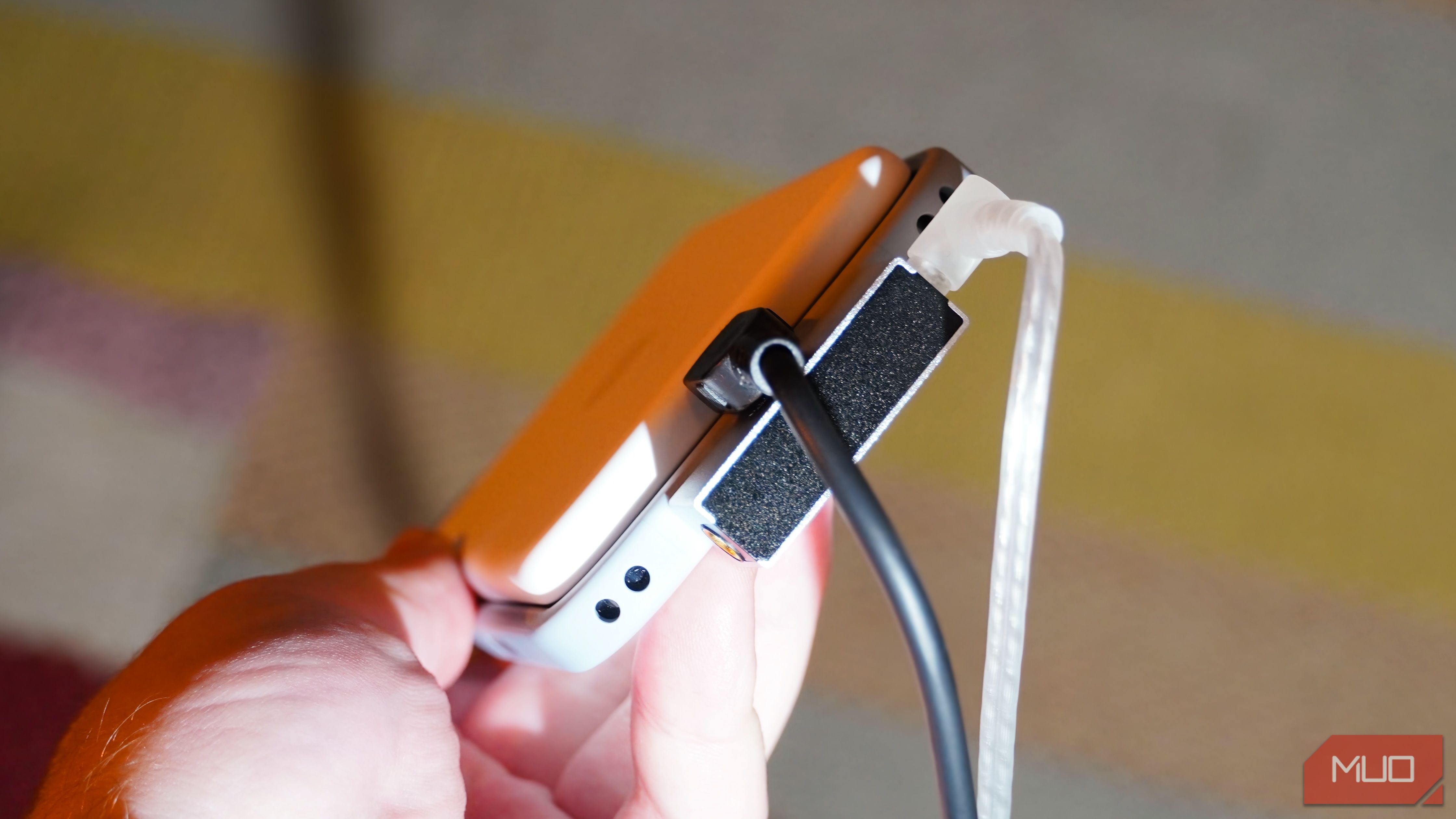 A MagSafe battery pack, DAC, charger, and headphones plugged into a phone.