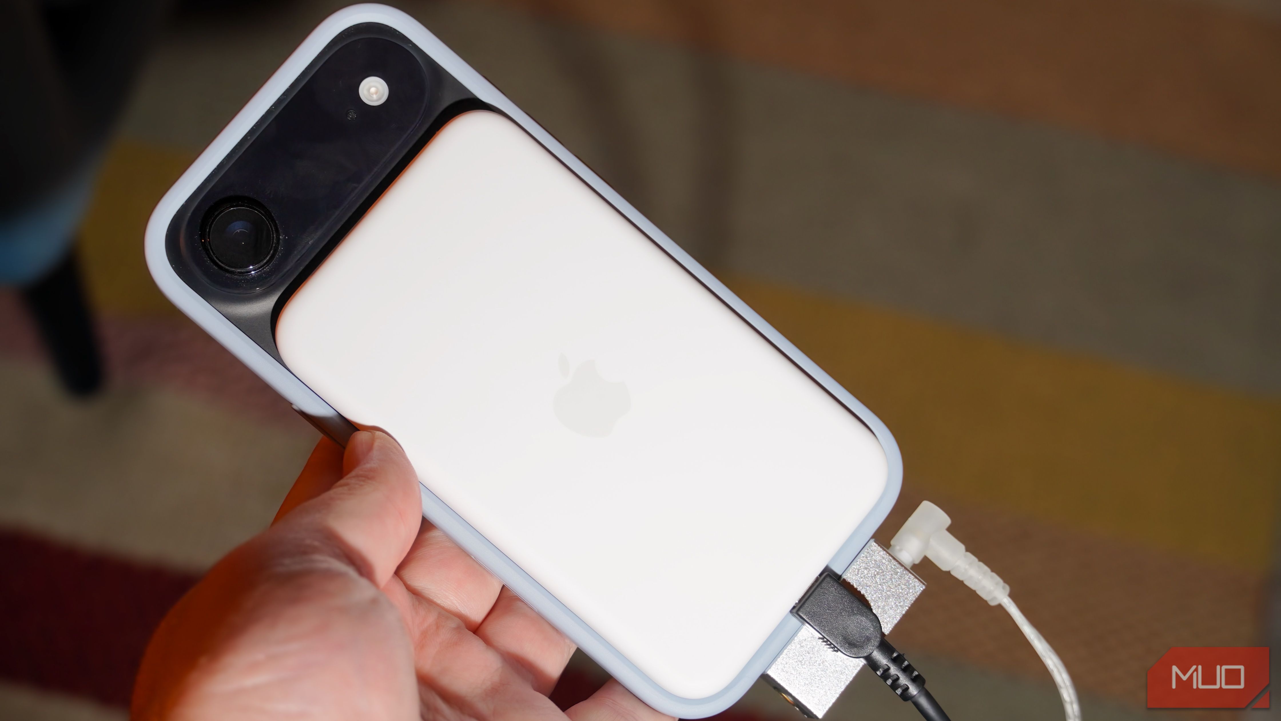 A MagSafe battery pack, DAC, charger, and headphones plugged into a phone.