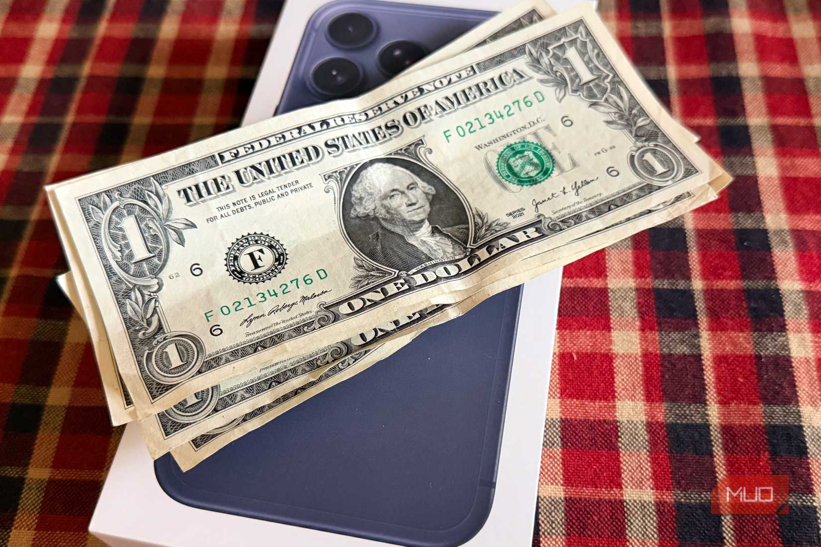 Some US dollars on top of an iPhone 17 Pro Max box. 