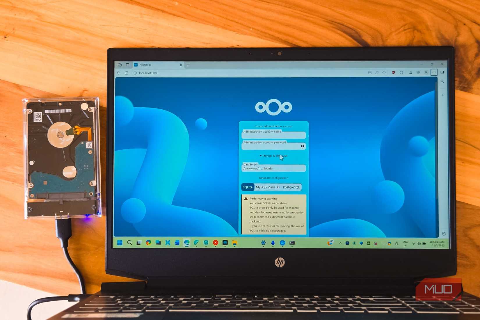 NextCloud ログインは、外付けハード ドライブが接続された木製テーブルの上に置かれた HP ラップトップで開いています。