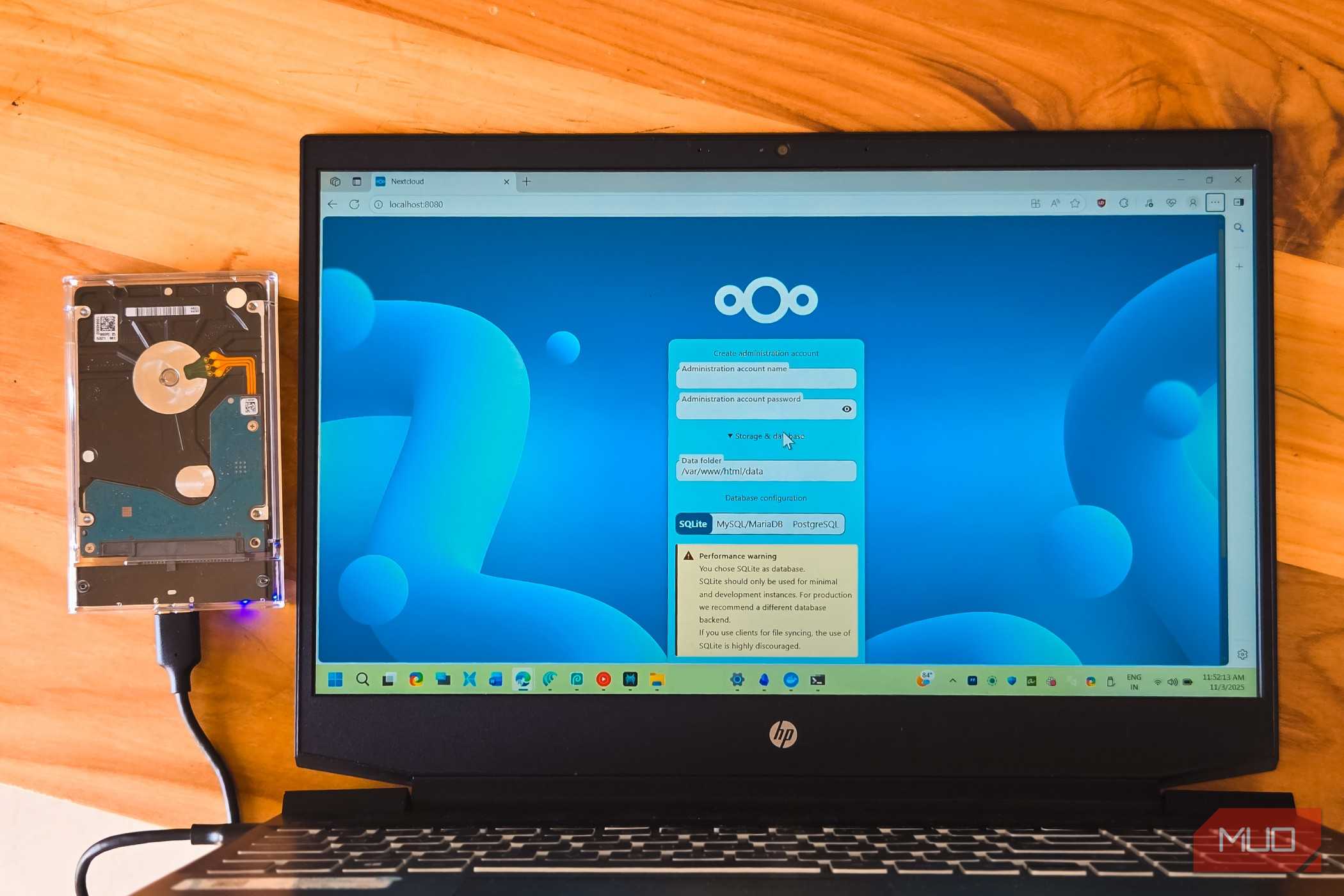 NextCloud login open on a HP laptop kept on a wooden table with an external HDD connected