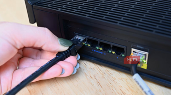 Person plugging in the Cable Matters ethernet cable into a router