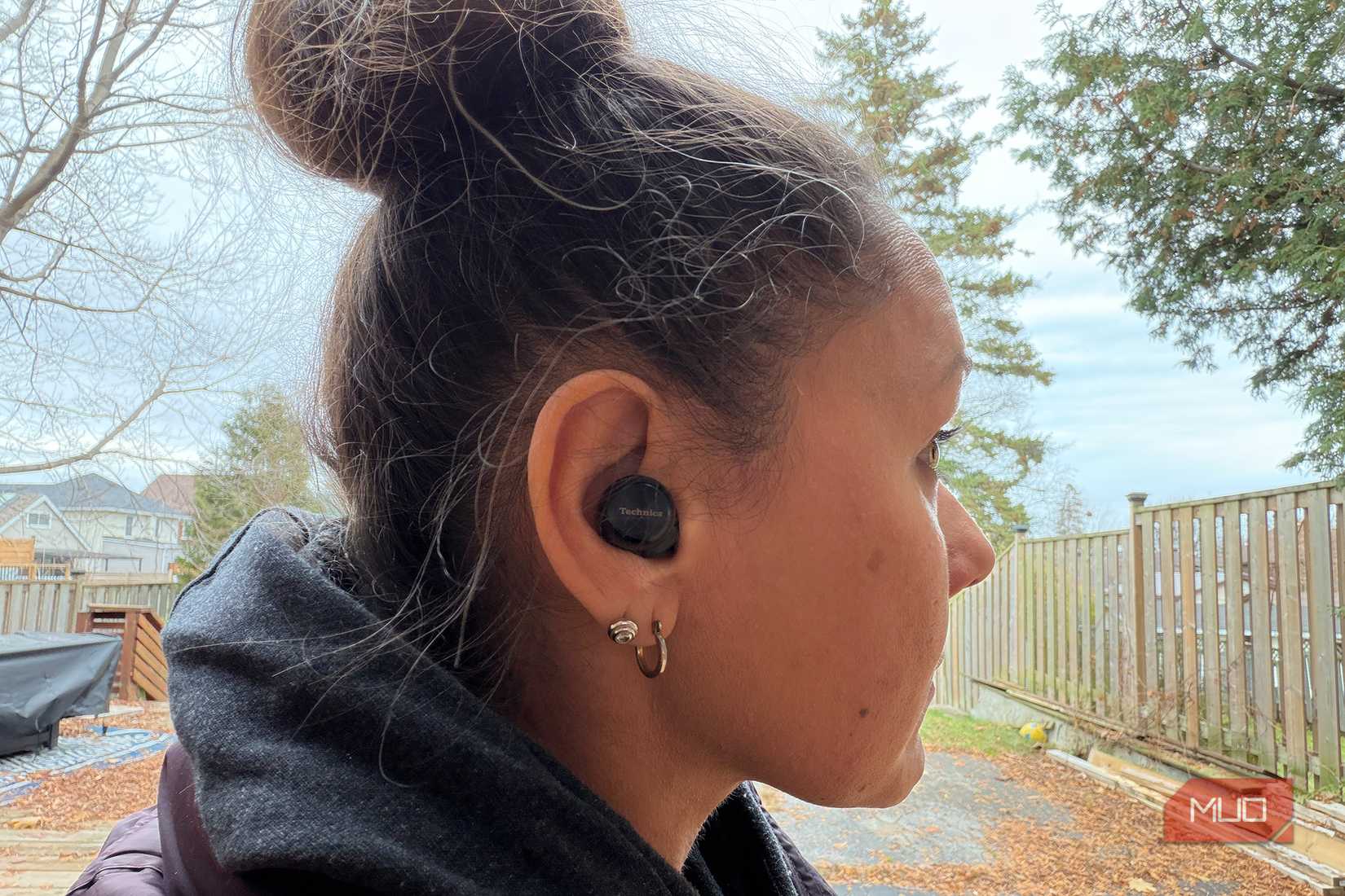 A woman outside wearing the Panasonic Technics EAH-AZ100 earbuds