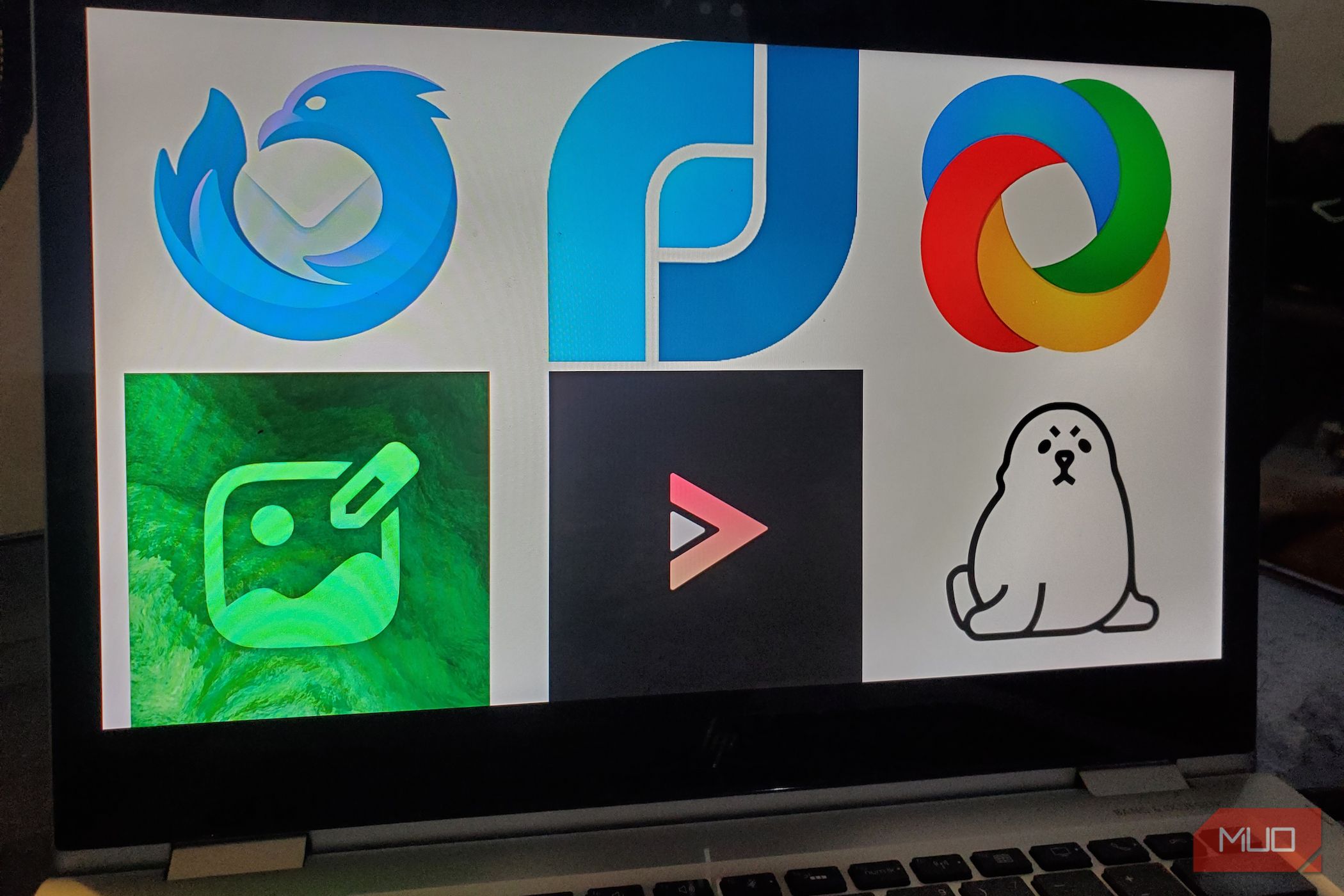 A laptop screen displaying a grid of six open-source app icons.