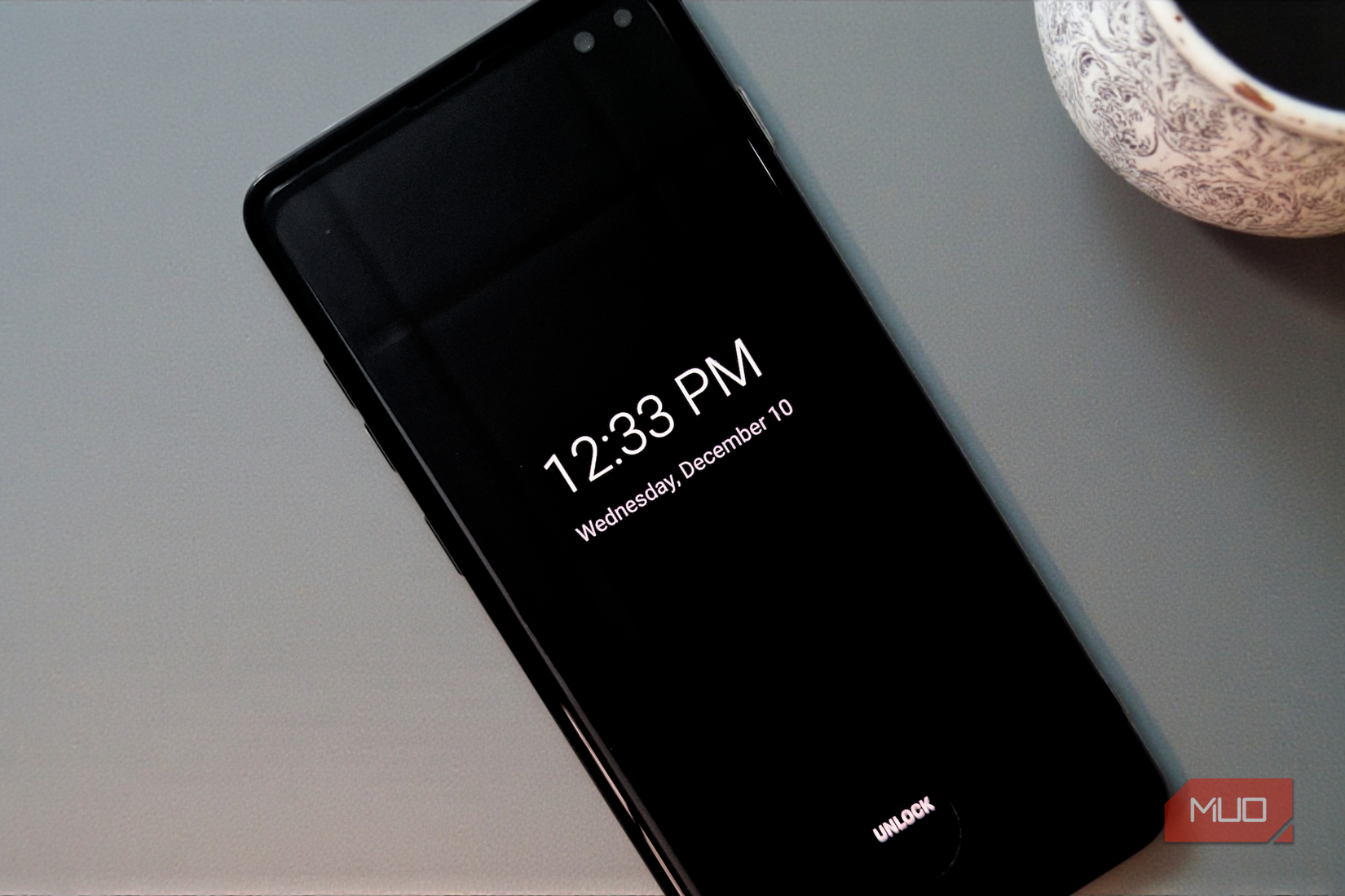 گوشیهوشمندی با نمایش همیشه روشن که روی میز قرار دارد.