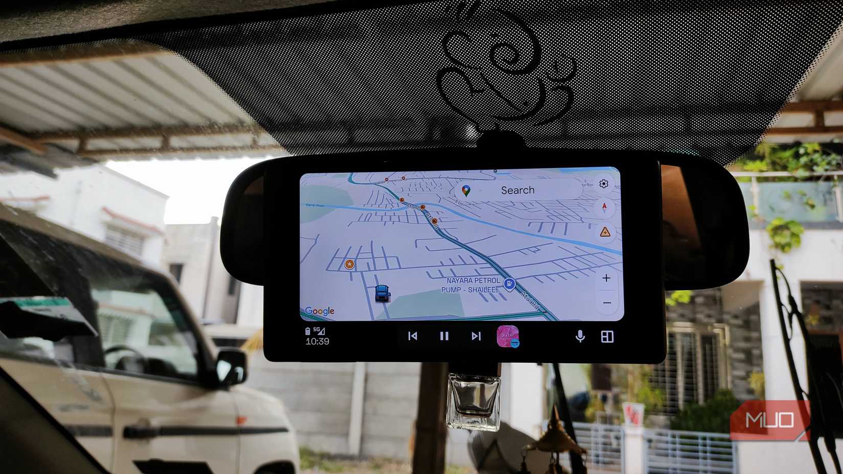 Tableta Android con Android Auto colocada en el espejo retrovisor del coche.