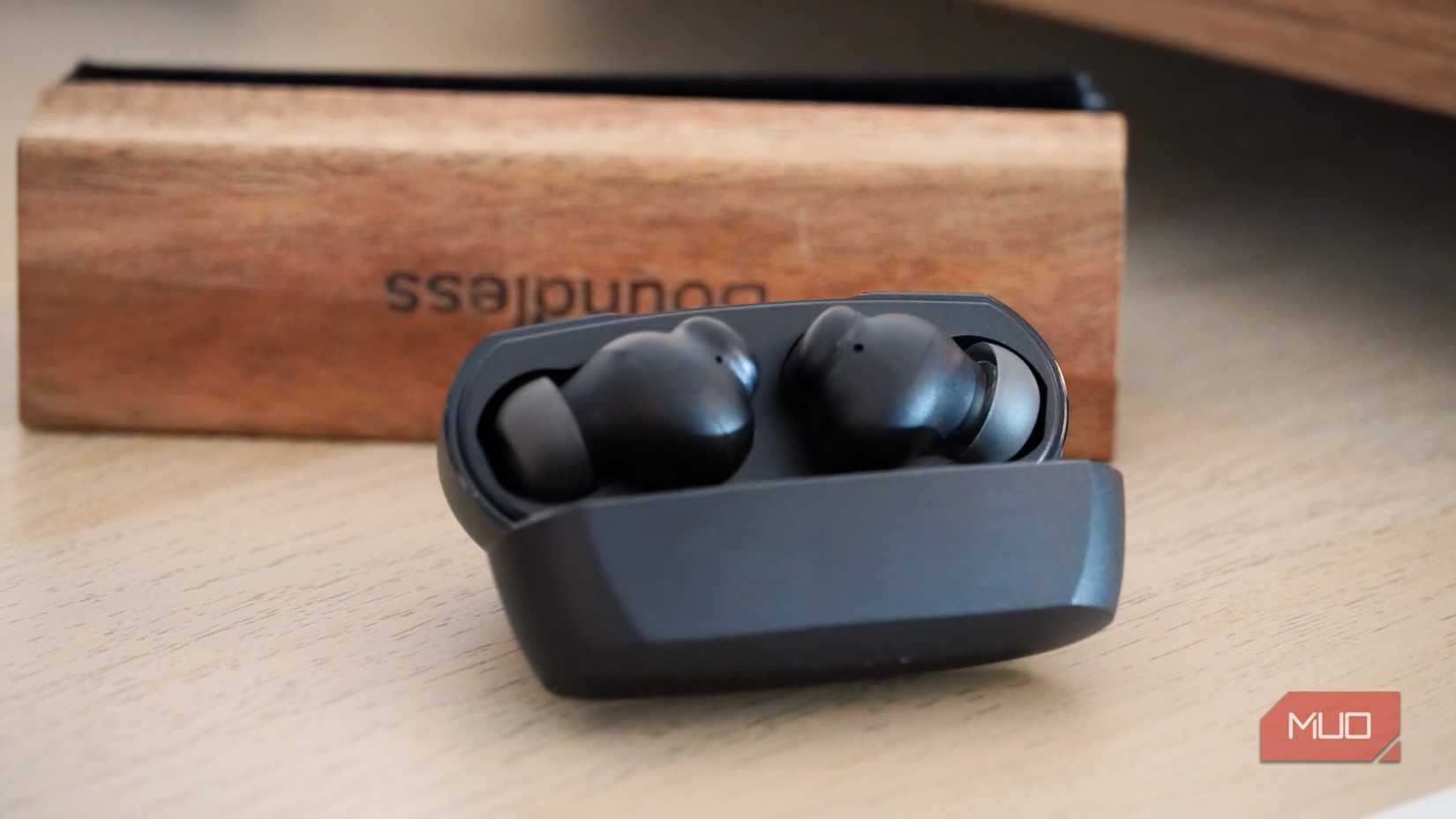 The Belkin SoundForm Rhythm ANC earbuds in front of a record cleaning brush.