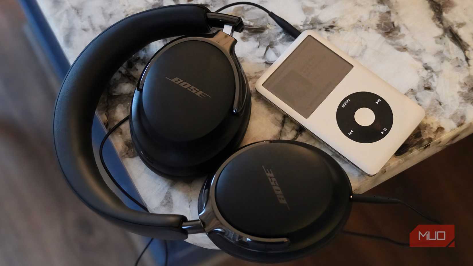 The Bose QuietComfort Ultra Gen 2 headphones folded and connected to an iPod. 