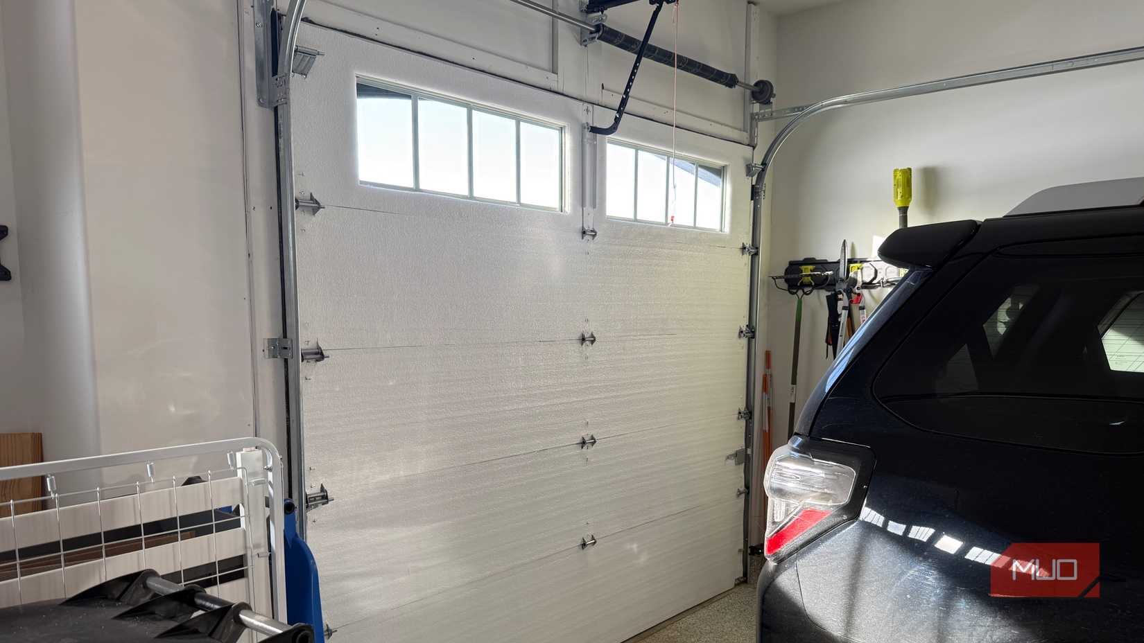 complete insulated garage door with black car in garage