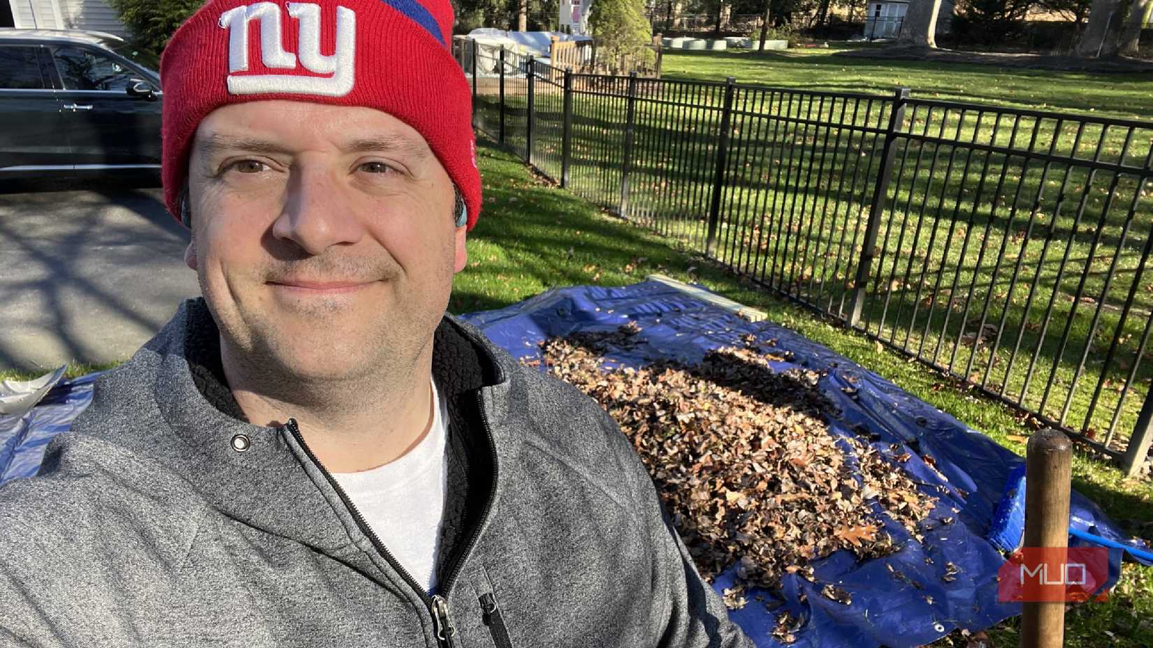 Una persona parada frente a hojas sobre una lona.