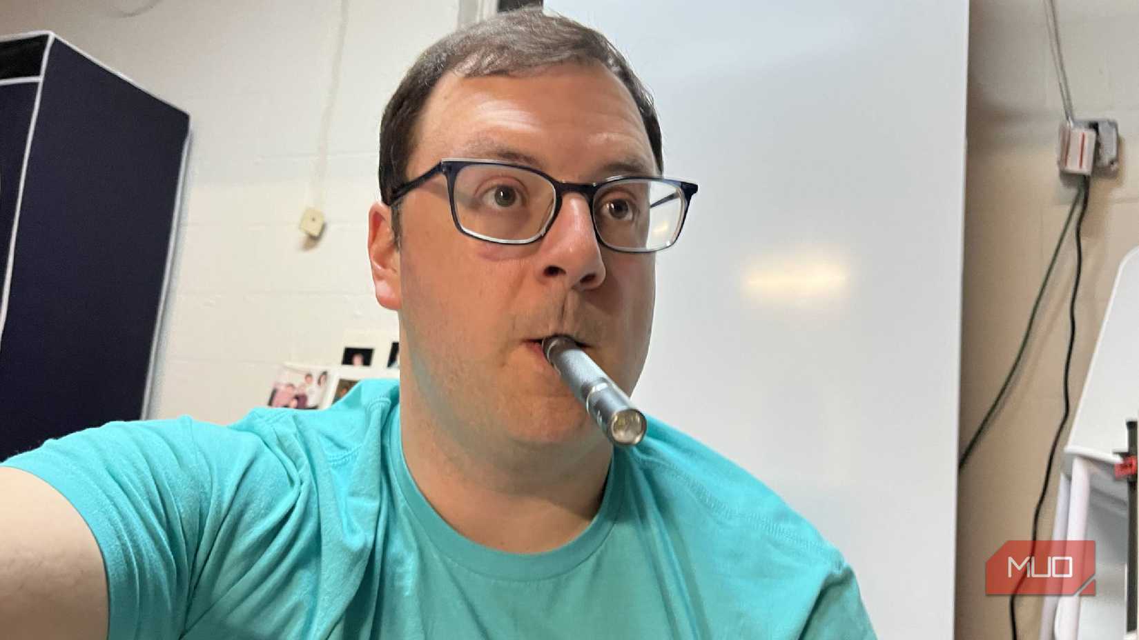 A penlight being held in a mouth while working