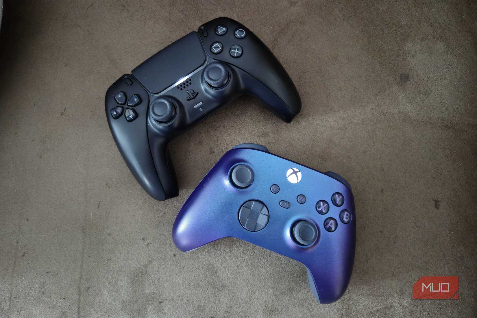 A black DualSense and a purple Xbox Series X controller