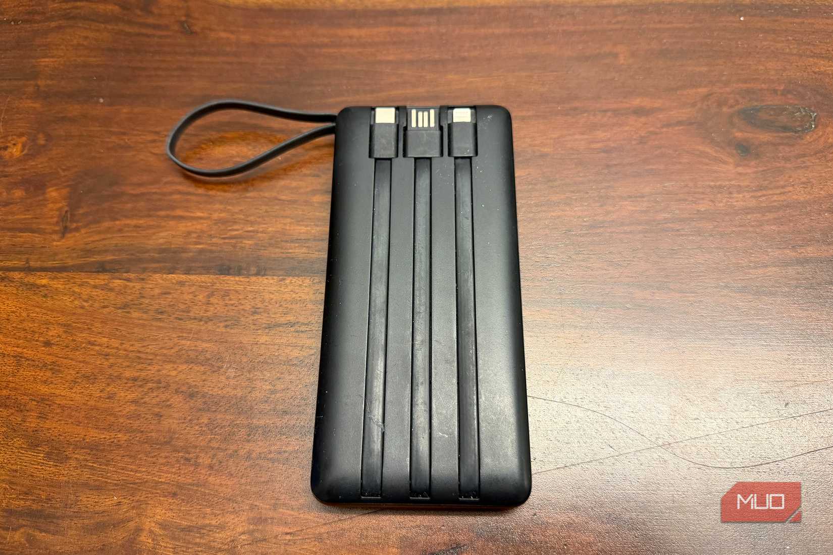 The back of a power bank with three cables built-in and recessed in the back.