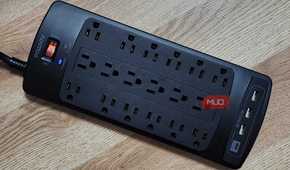 The Powsav 18-Plug Surge Protector, plugged in with one glowing light