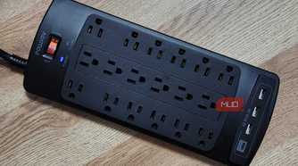 The Powsav 18-Plug Surge Protector, plugged in with one glowing light