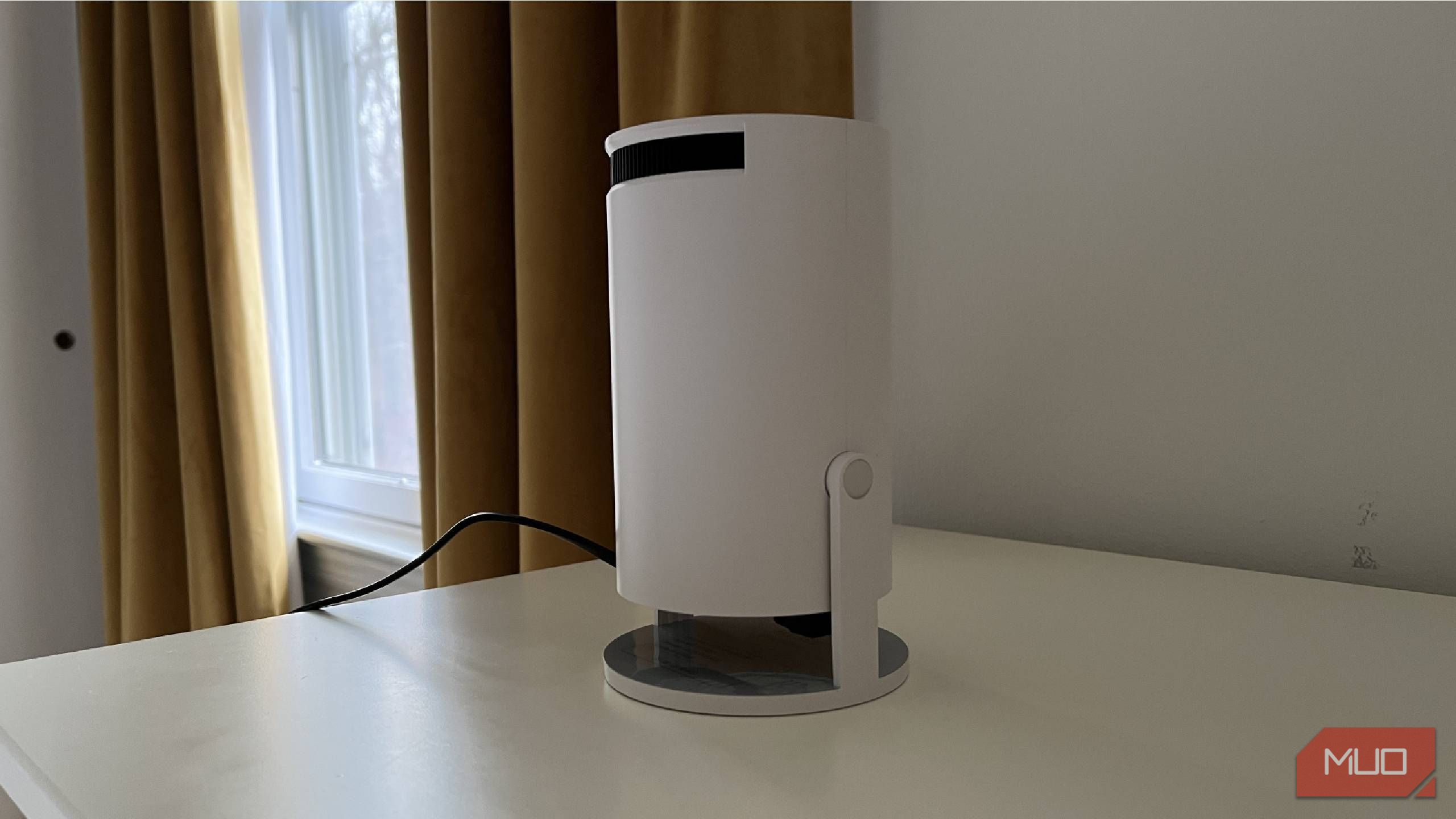 A Magcubic Auto Keystone Mini Portable Projector on a dresser