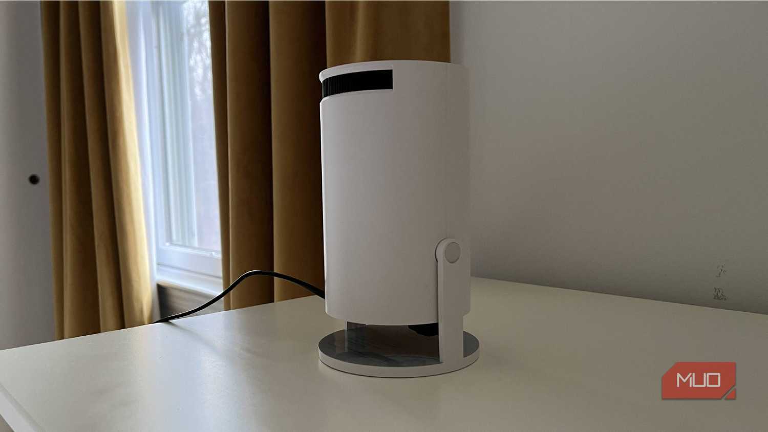 A Magcubic Auto Keystone Mini Portable Projector on a dresser
