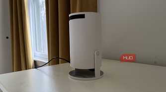 A Magcubic Auto Keystone Mini Portable Projector on a dresser