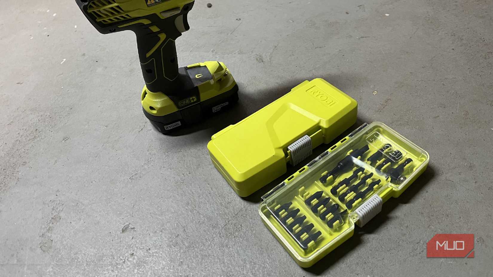 A set of driver bits and drill bits near a RYOBI ONE drill