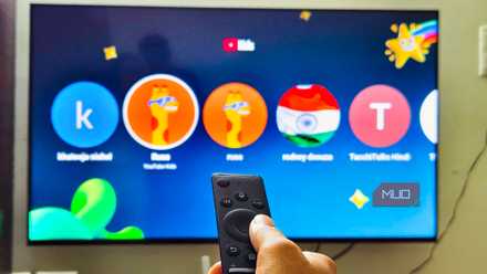 Samsung TV Remote infront of a Samsung Smart TV with YouTube app open