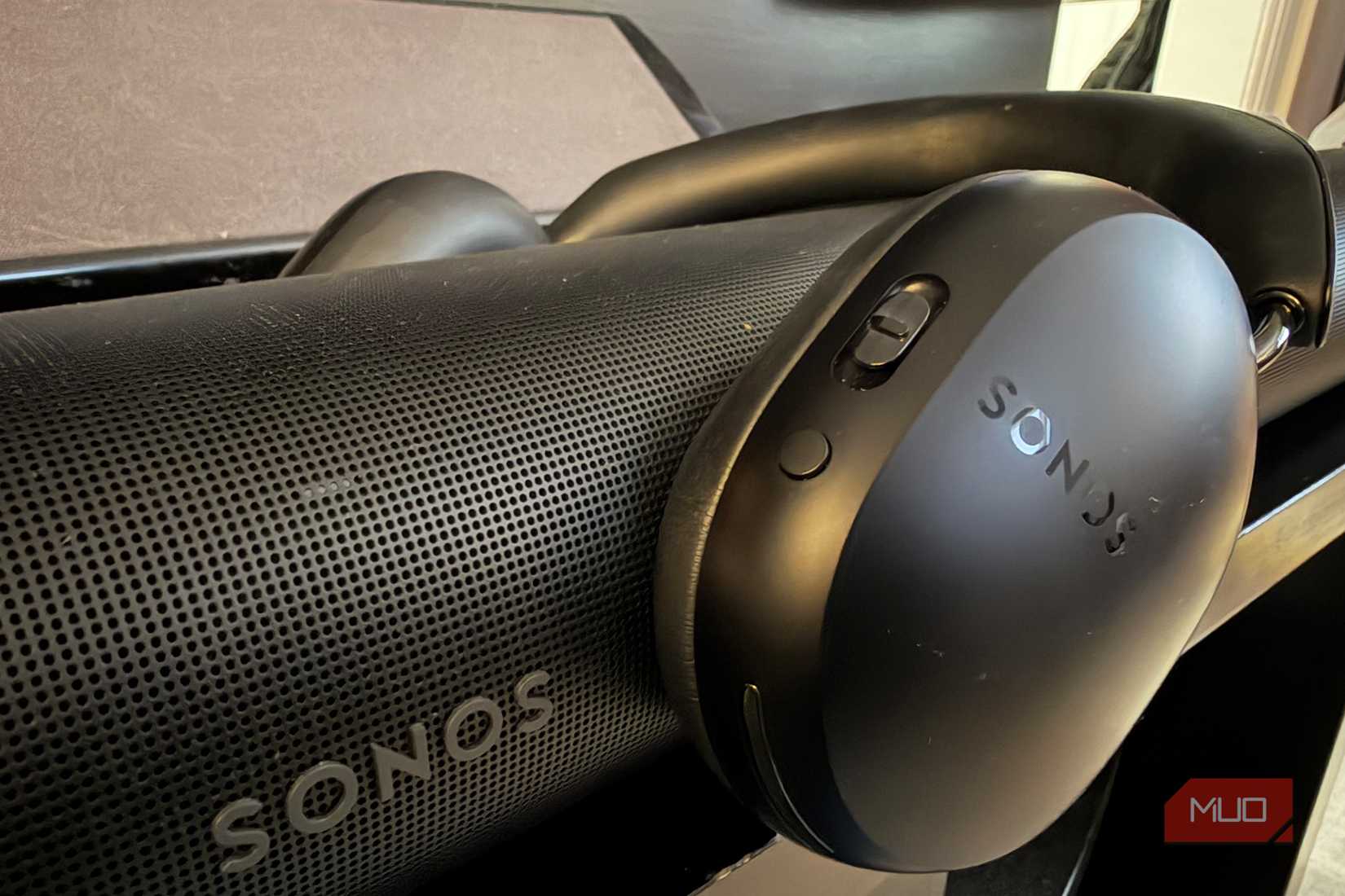 The Sonos Ace headphones wrapped around a Sonos Arc soundbar.