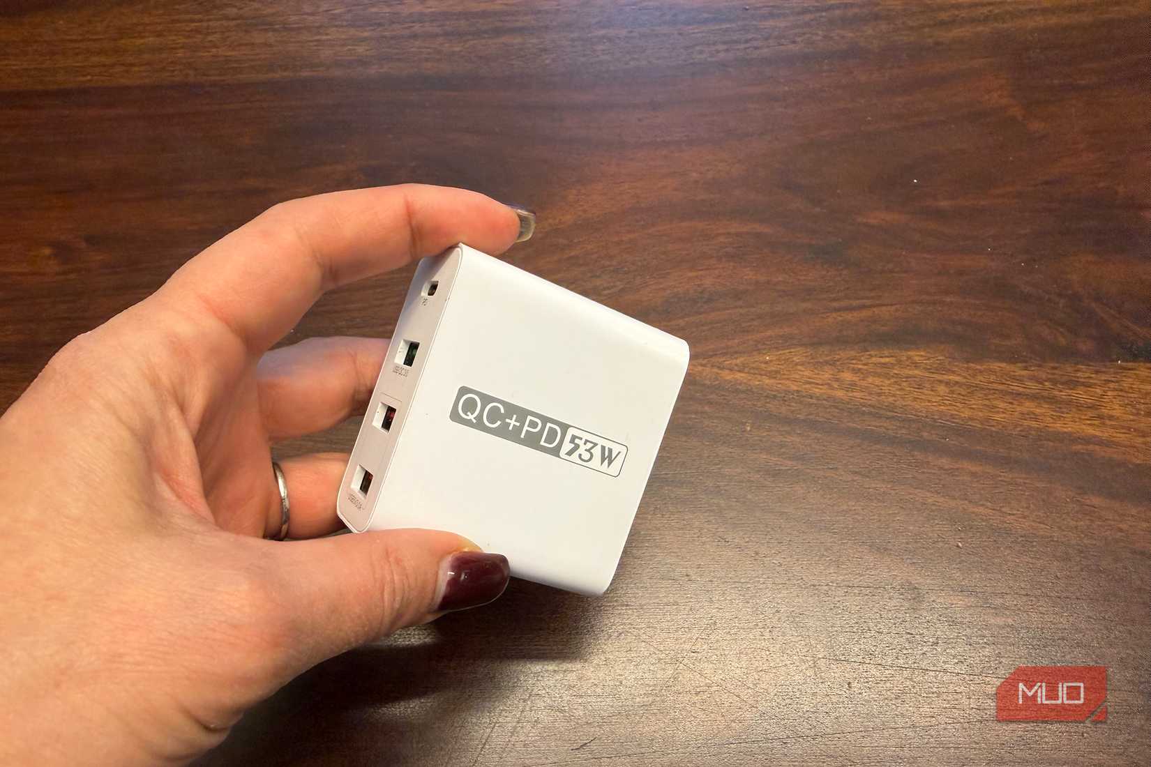 A hand holding a charging brick.