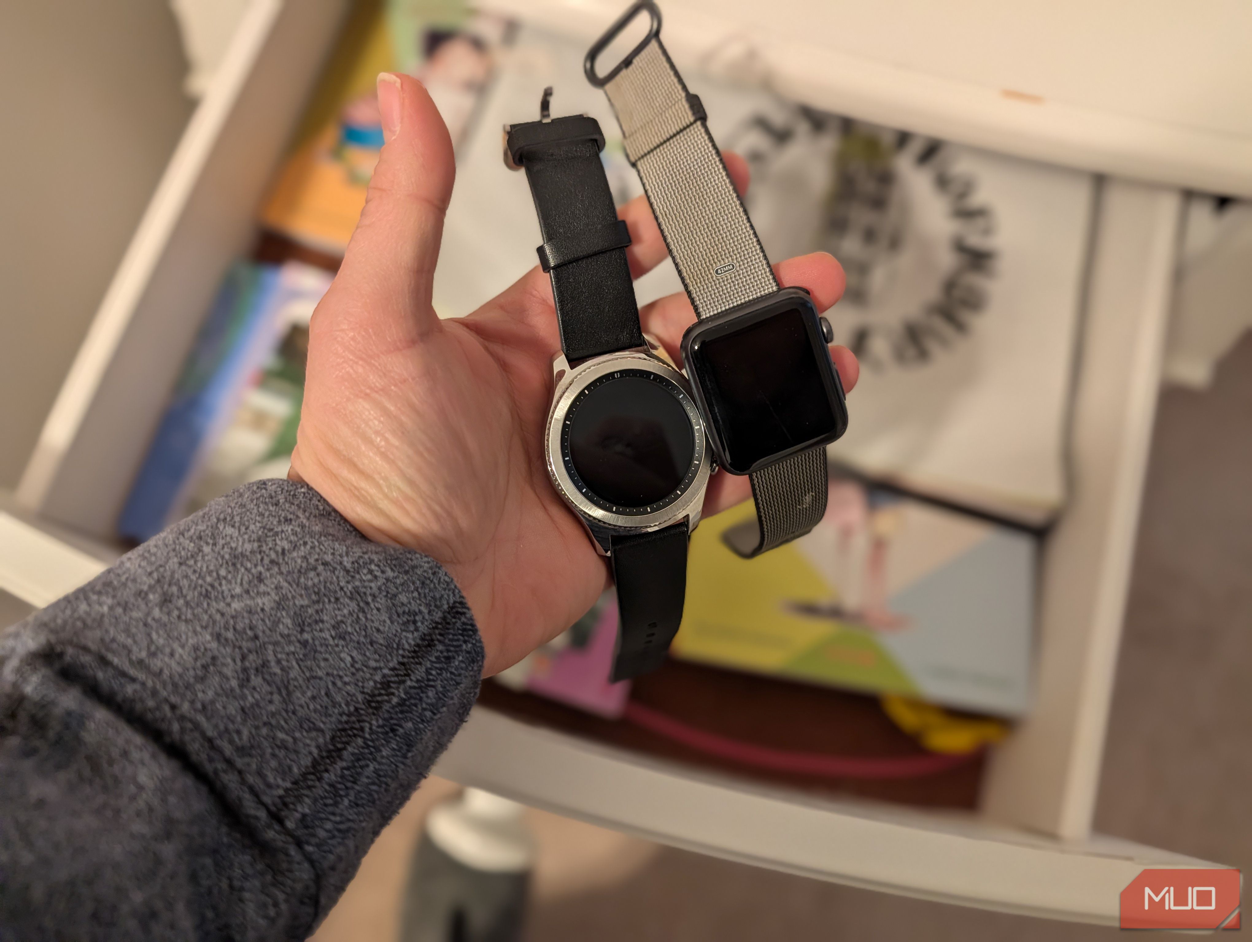 Person holding old smartwatches