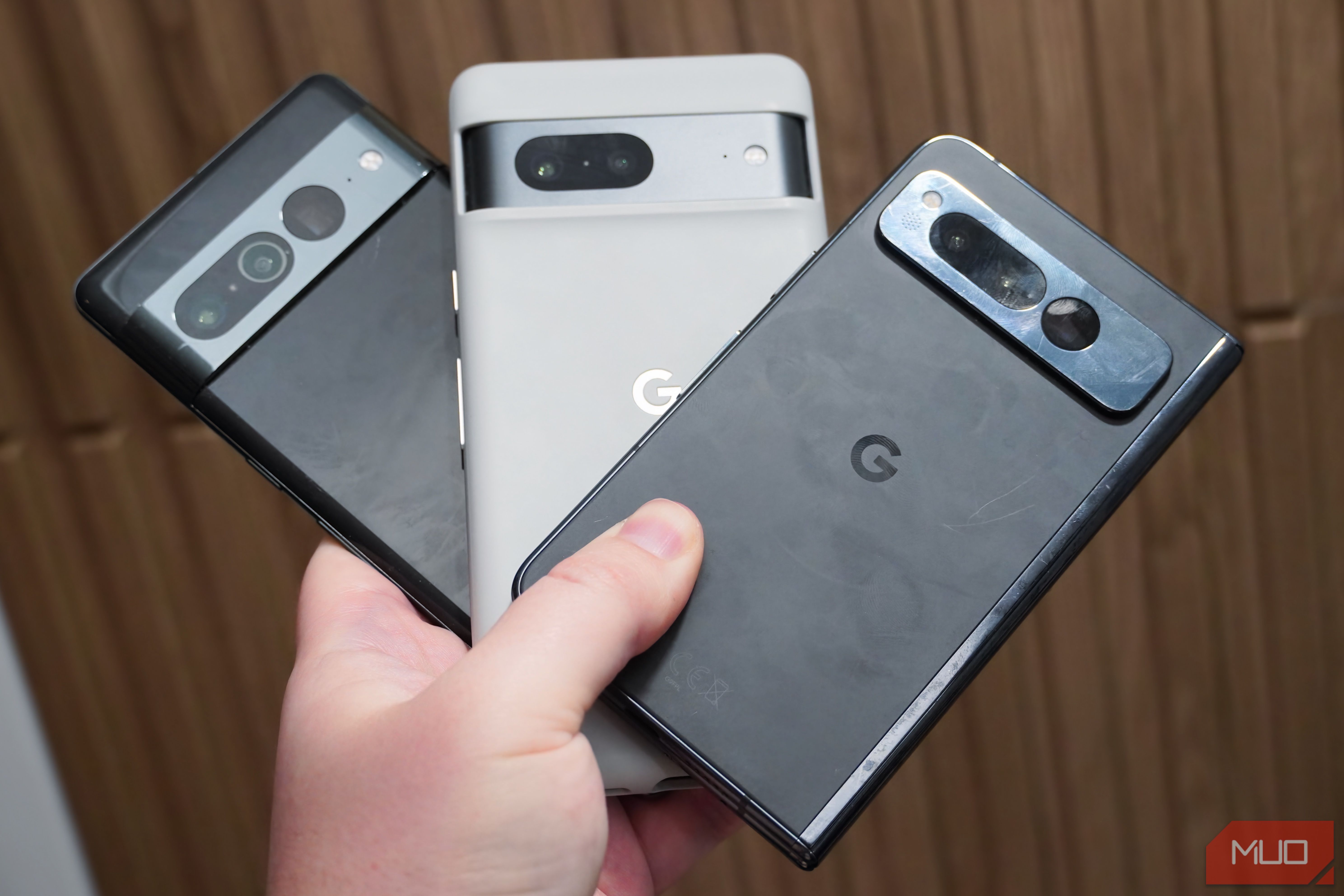 Holding a Google Pixel 7, Google Pixel 7 Pro, and Google Pixel Fold in the hand.