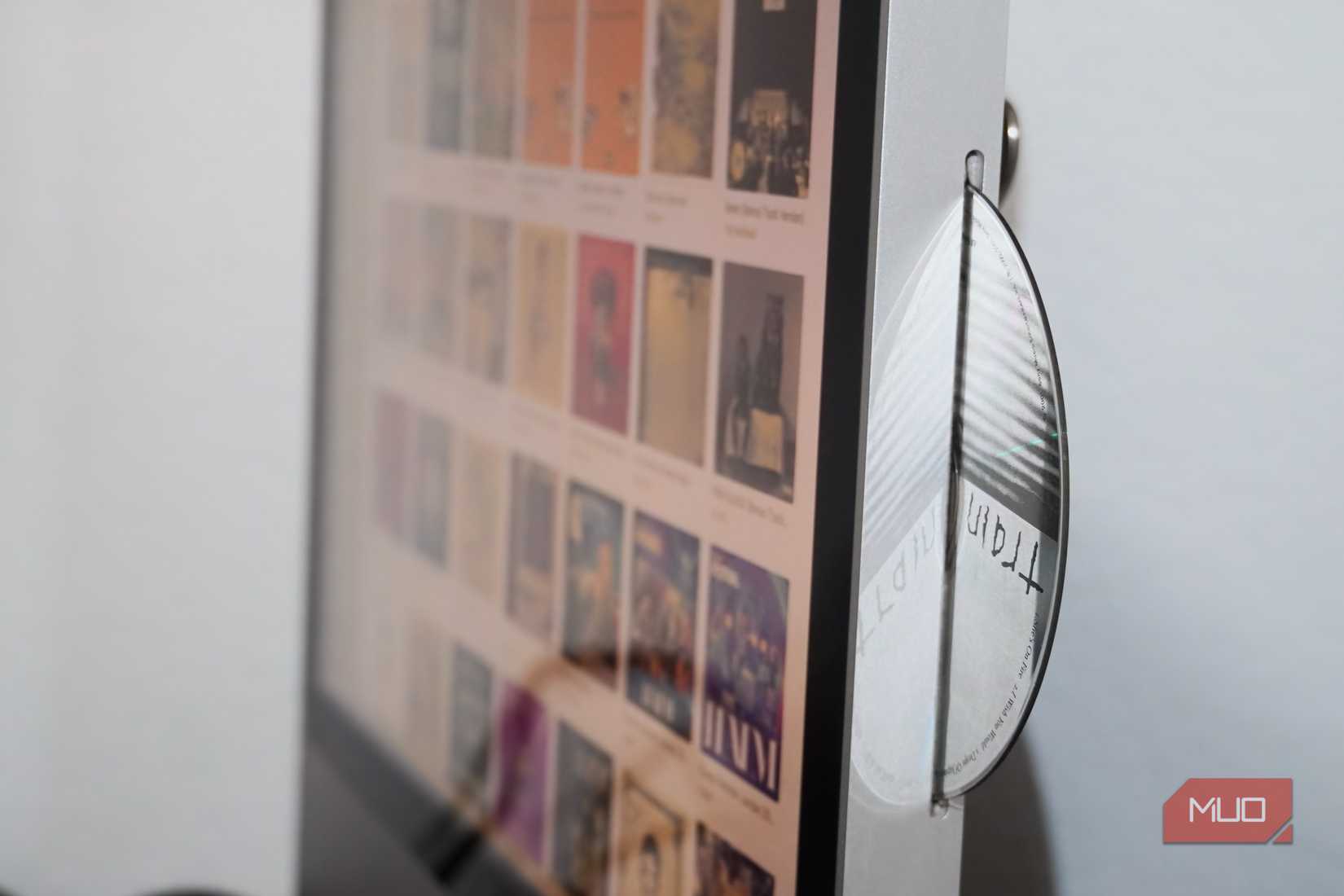 A CD half inserted in an iMac running iTunes.