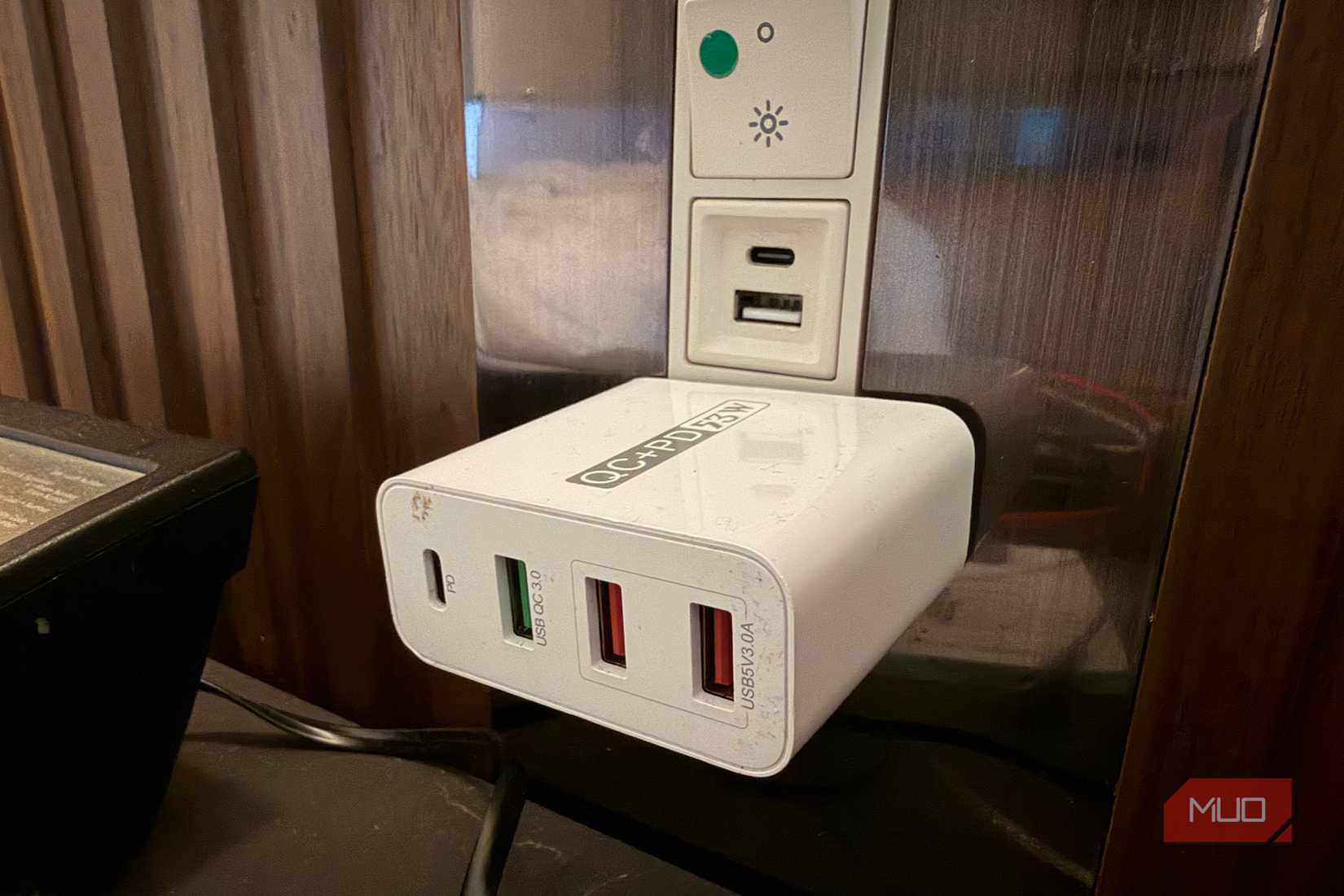 Close up of a multi-port wall adapter plugged into an outlet.