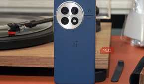 The OnePlus 13 in blue leaning against a vinyl record player.
