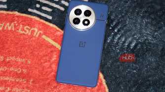 The blue OnePlus 13 on a vinyl-themed rug.