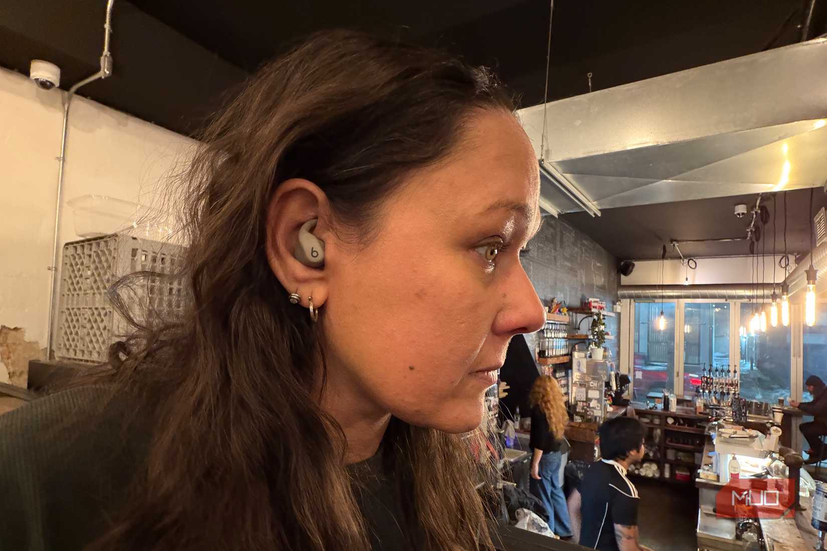 A woman's side profile wearing the Powerbeats Fit.
