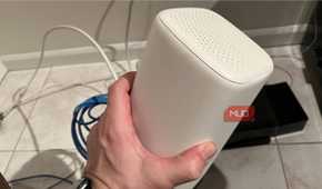 The top and side of a Wi-Fi router being held
