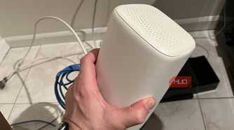 The top and side of a Wi-Fi router being held