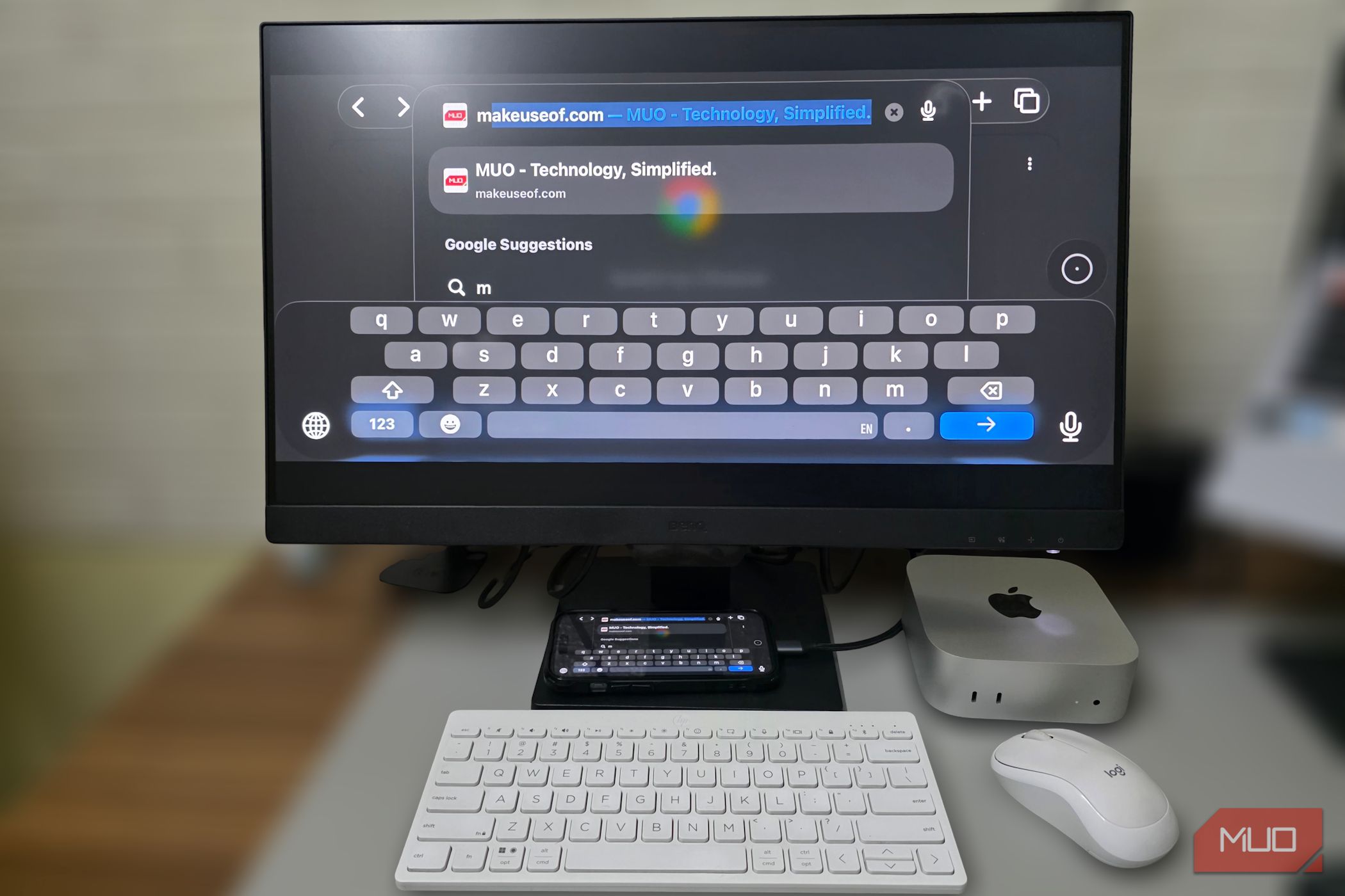 Typing on a phone mirrored to a monitor using a keyboard and mouse