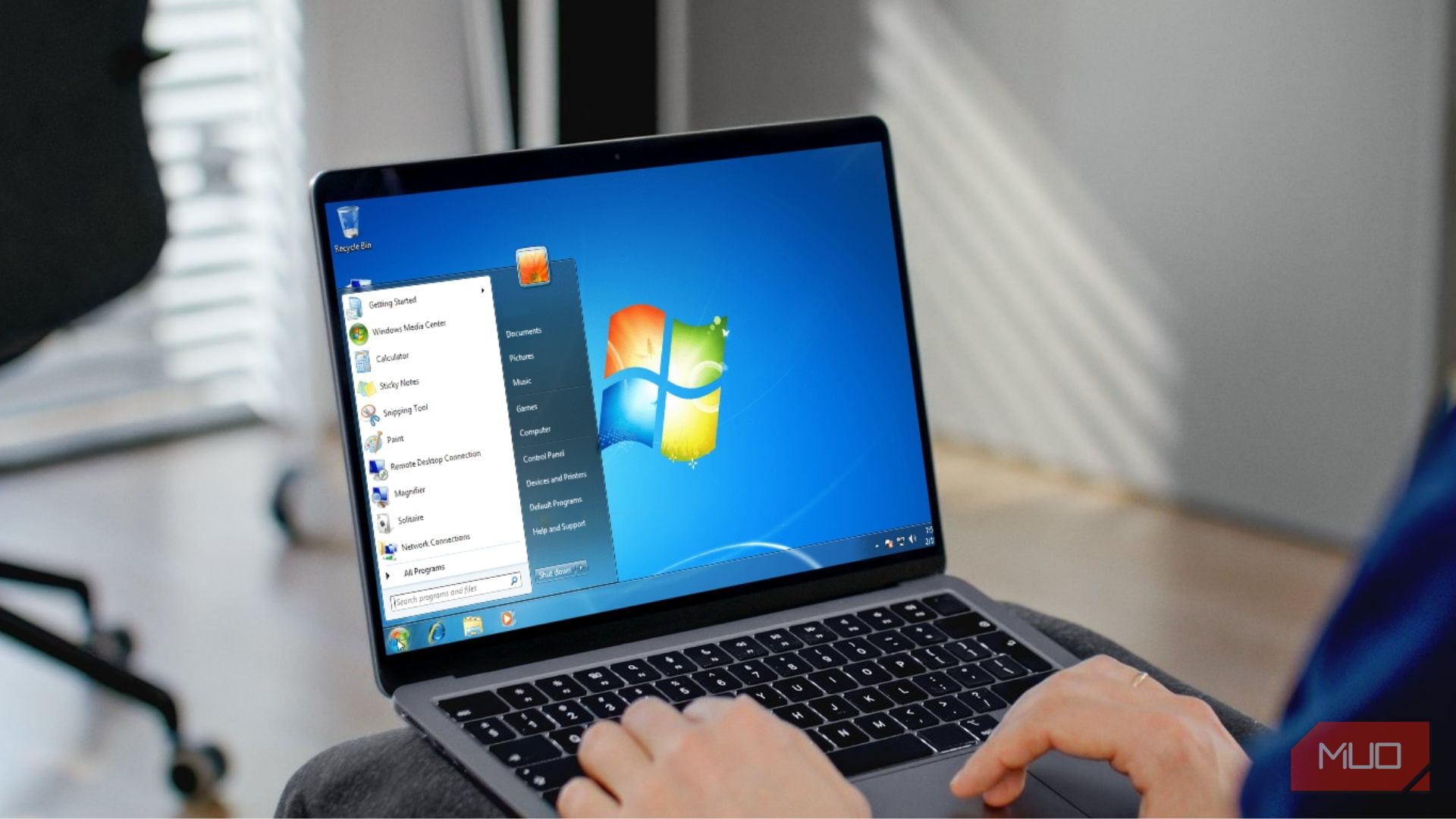 A person working on a Windows 7 laptop mockup