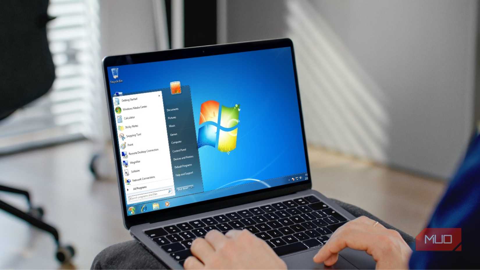 A person working on a Windows 7 laptop mockup