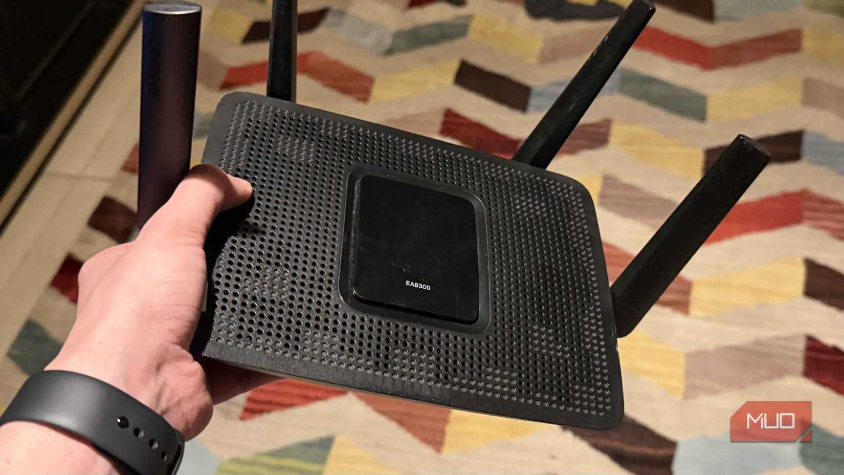 হাতে একটি Linksys EA8300 রাউটার রাখা