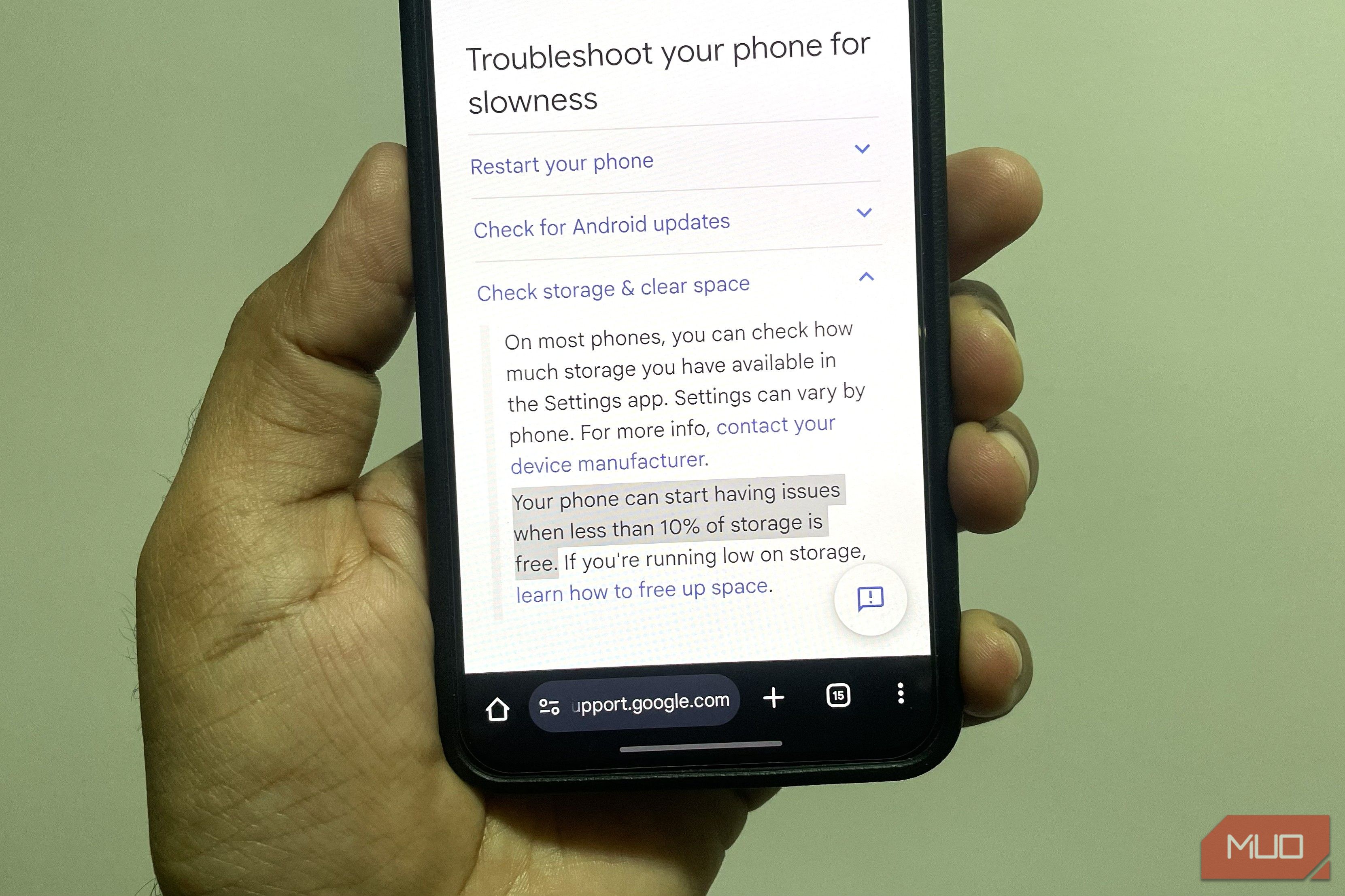 Android phone in hand showing Google support page