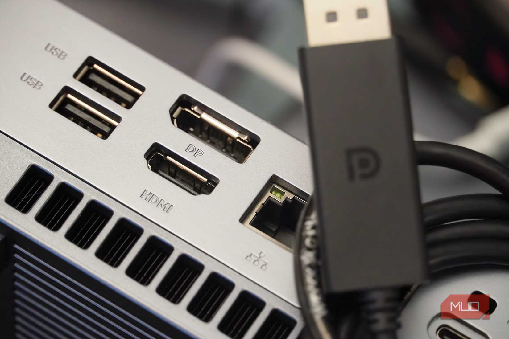 DisplayPort cable sitting atop a Mini PC with DP and HDMI inputs.