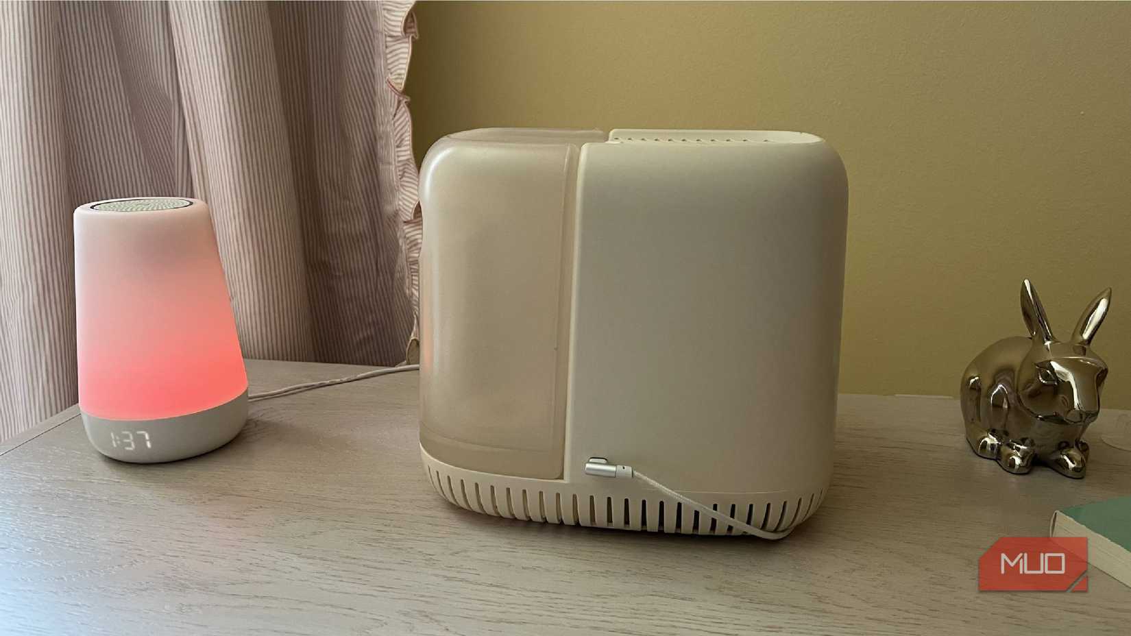 A humidifier on a dresser next to an alarm clock