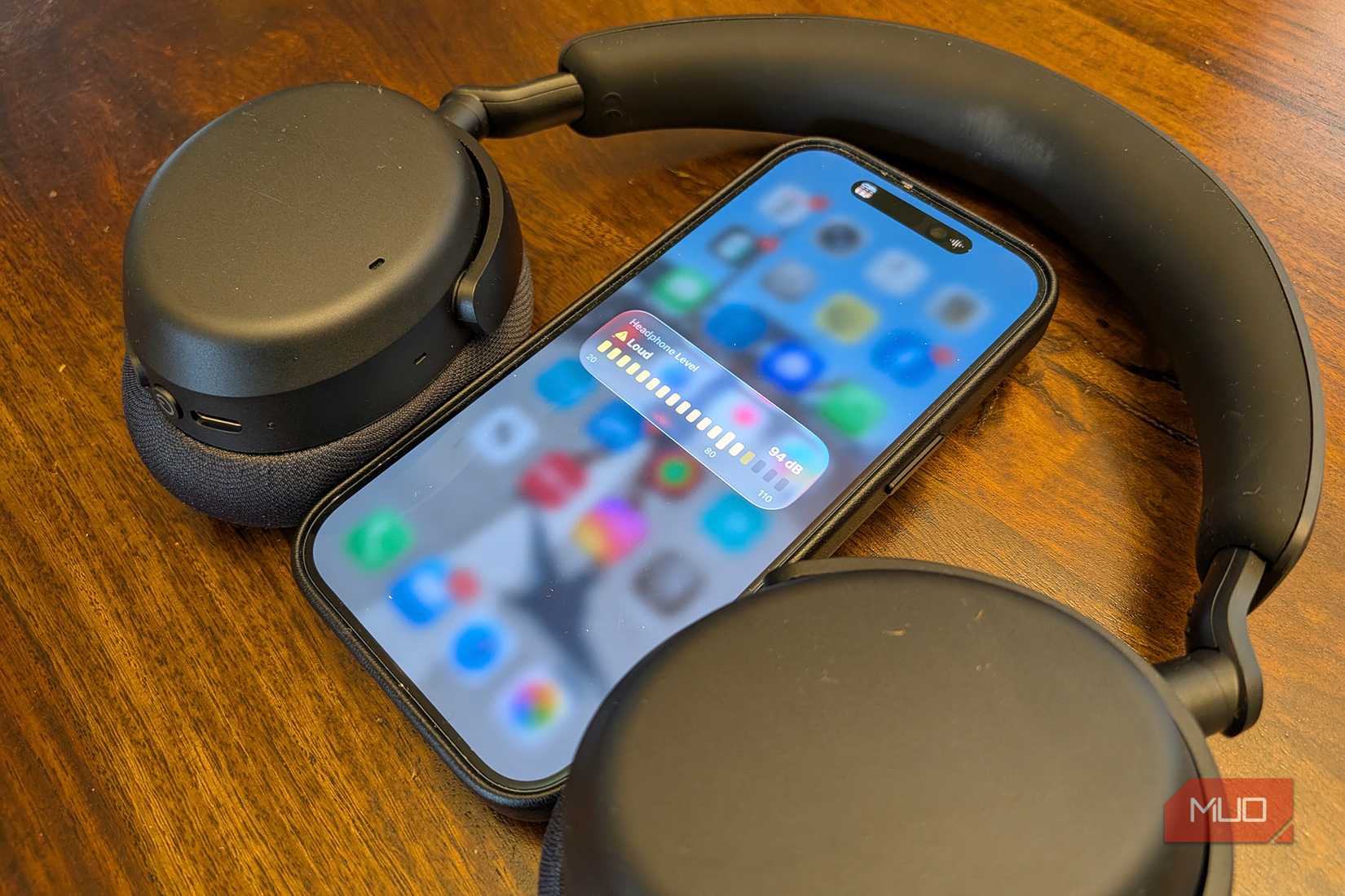 হেডফোনের মাঝখানে একটি আইফোন উচ্চ শব্দ দেখাচ্ছে।