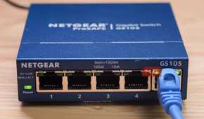 A close-up of the Ethernet cable plugged into an unmanaged switch.